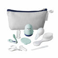 The Nuby Baby Healthcare and Grooming Kit includes a nail clipper, scissors, brush, silicone finger toothbrush, medicine dropper, nasal aspirator, silicone scrubber, seal-shaped item, and a white pouch—all organized neatly in front of the pouch.
