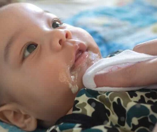 Baby with reflux having sick cleaned away