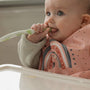 A baby chewing on a Nuby spoon while teething.