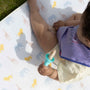 A baby holding a Nuby weaning apparatus.