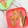 An overhead image of the Tortilla pizzas created and placed on red and green plates.