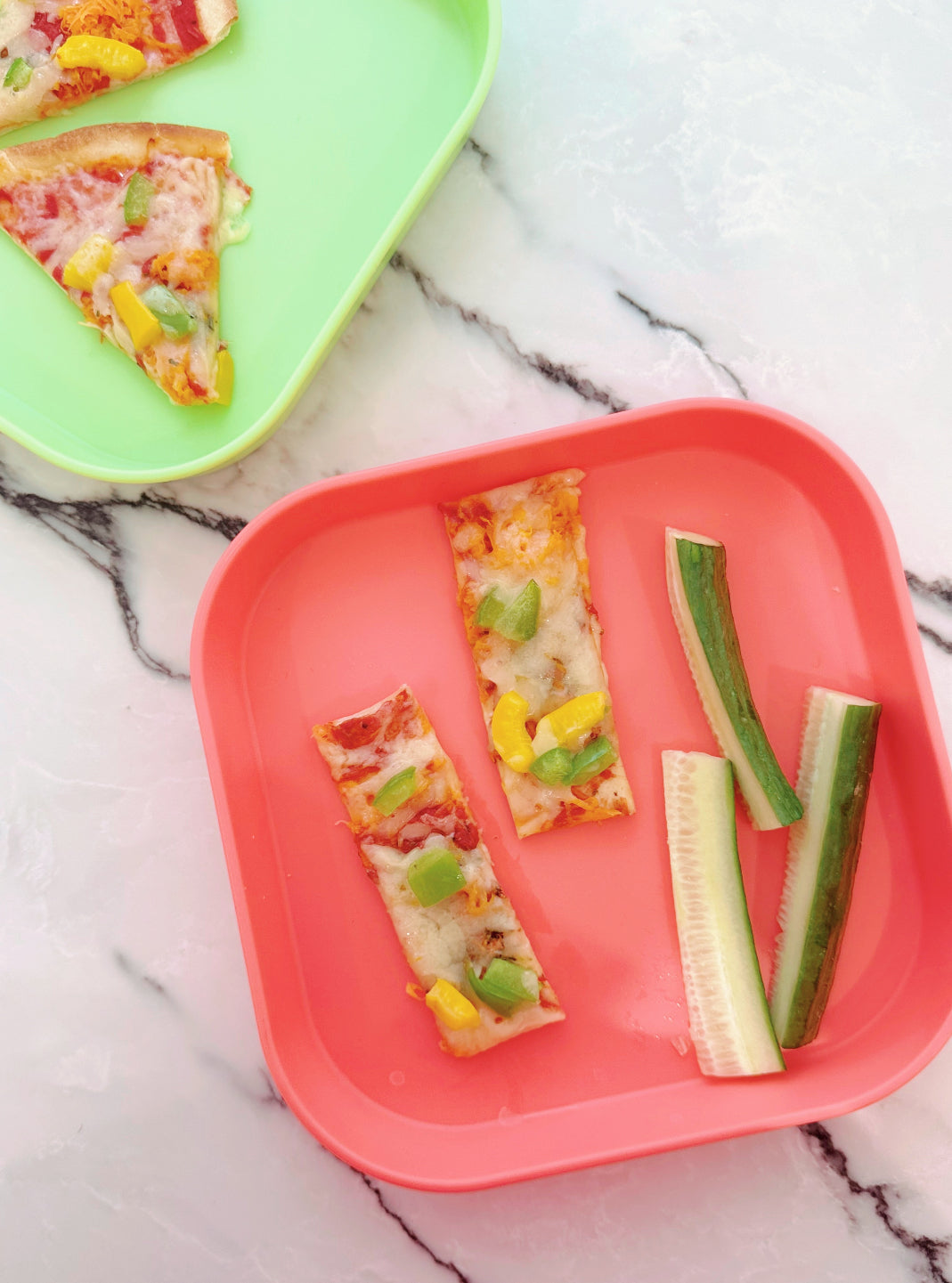 An overhead image of the Tortilla pizzas created and placed on red and green plates.