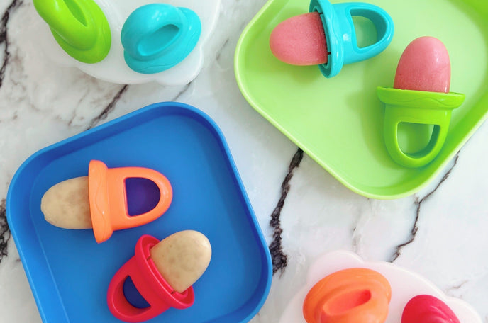 A set of plates with ice lollies placed on top that are safe for kids.