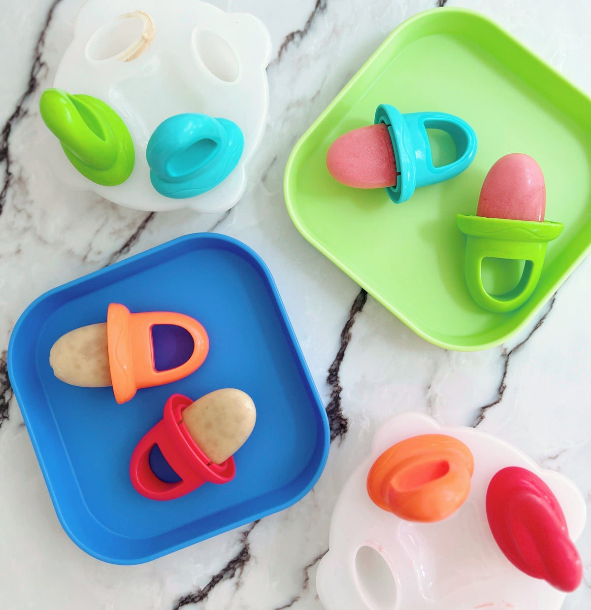 A set of plates with ice lollies placed on top that are safe for kids.