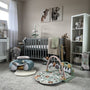 A baby's nursery in neutral colours includinng a play gym and sit up seat.