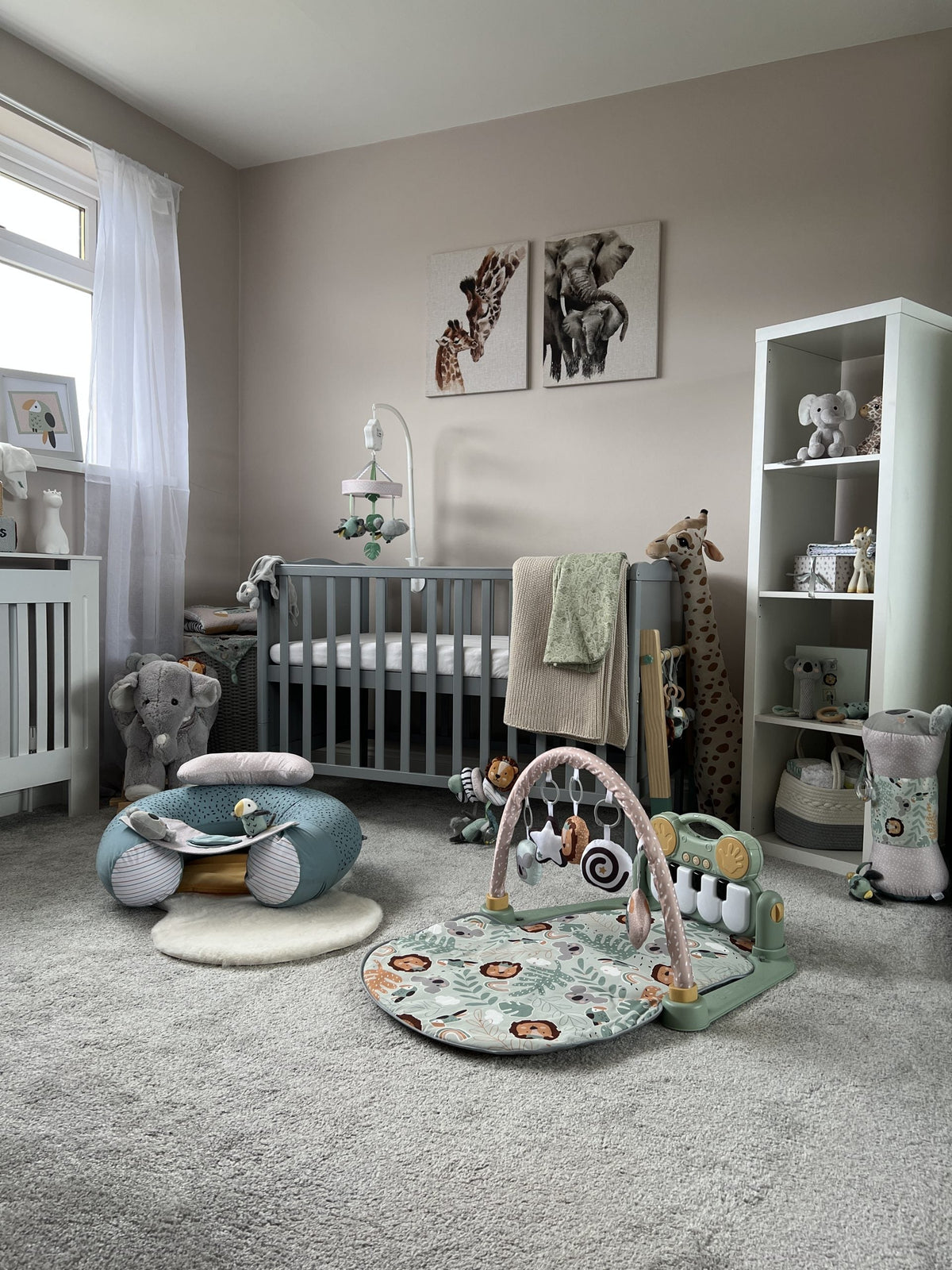 A baby's nursery in neutral colours includinng a play gym and sit up seat.