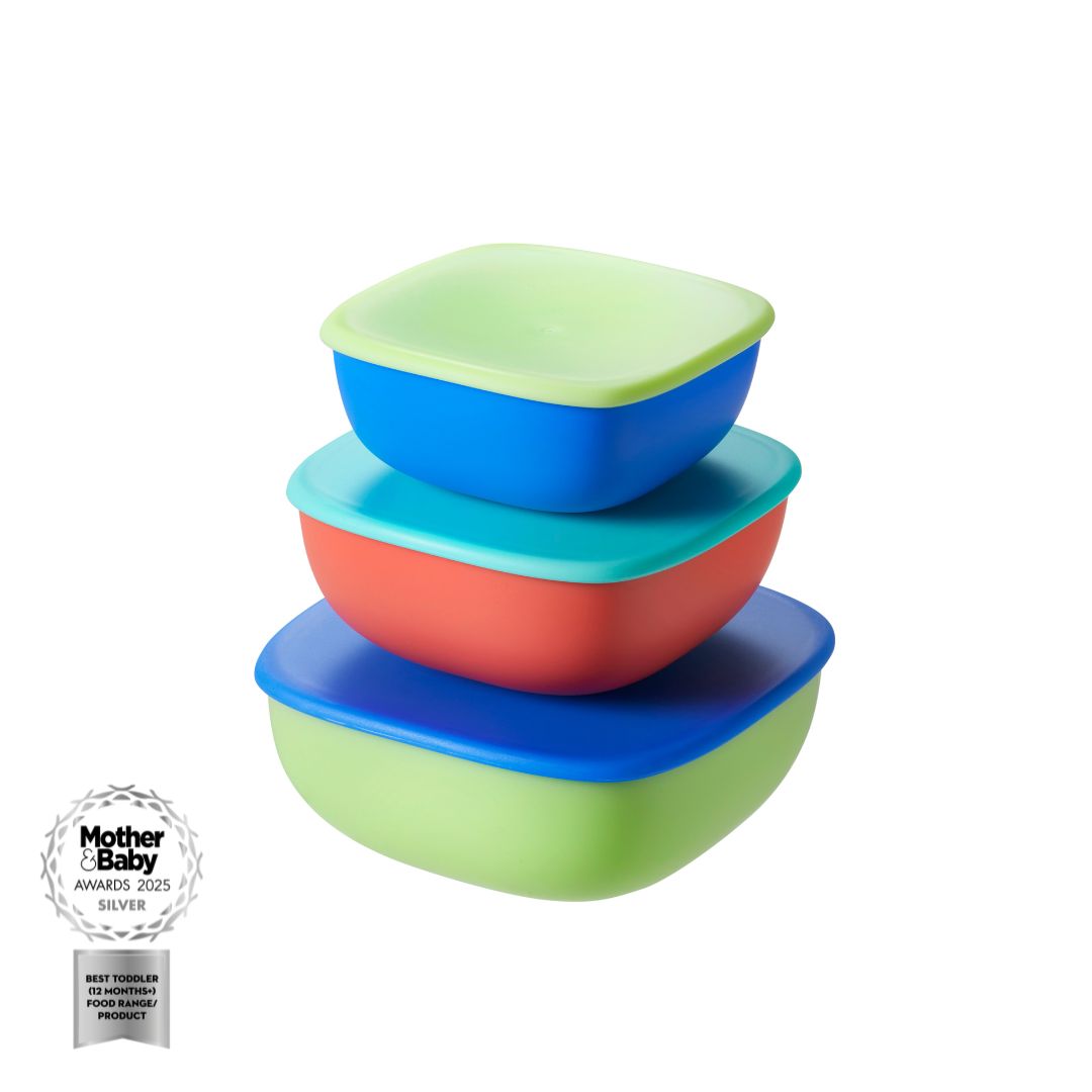 Three square, stackable Nuby Nesting Food Containers for children in green, blue, and red with matching lids. A Mother & Baby Awards 2023 Silver badge is shown at the lower left on a white background. Brand: Nuby.
