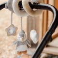 The Nuby Penguin Activity Spiral Travel Pram Toy features a plush penguin, star mirror, and white shape in neutral colors that hang from ribbons on strollers or car seat handles for fun and sensory play on the go.