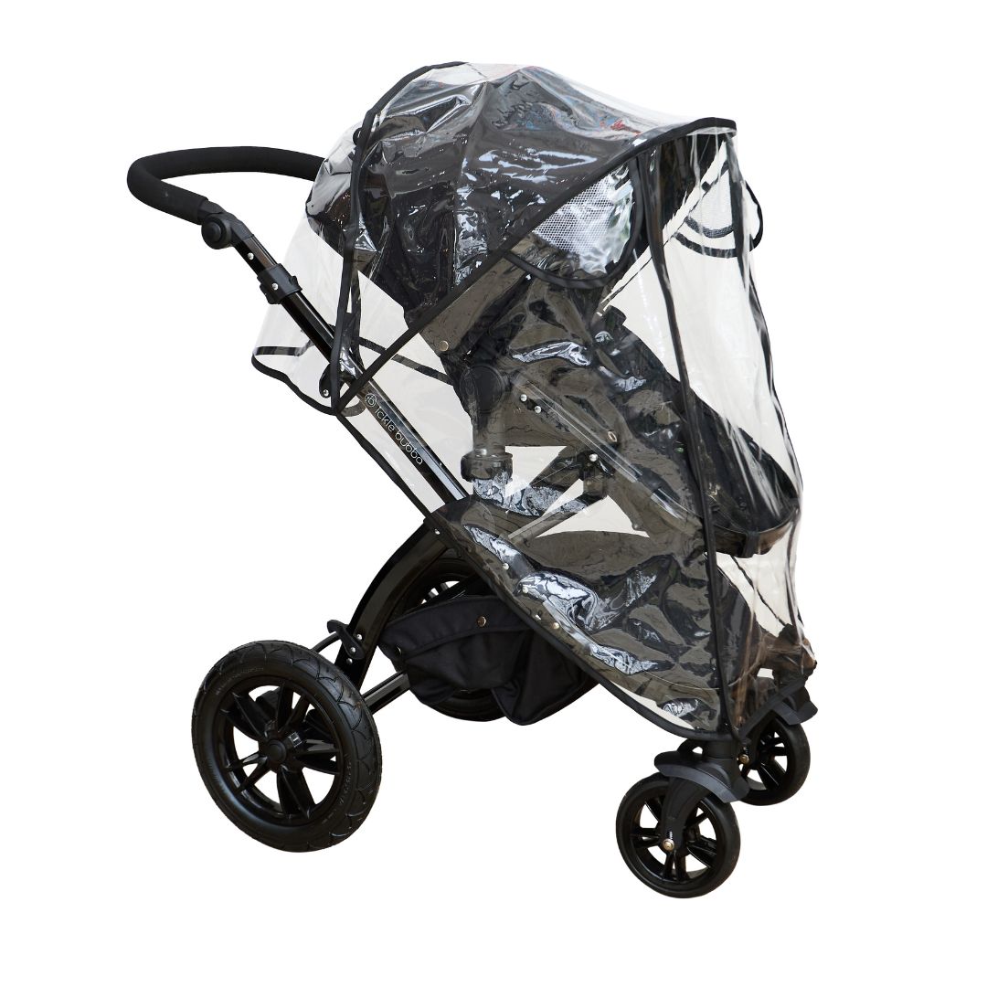 A black baby stroller fitted with a transparent Pram Rain Cover, protecting the seat and wheels, is shown from the side against a white background.