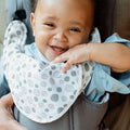 A close up of a baby that is smiling while sat inside the 2 in 1 Baby Carrier created by Nuby.