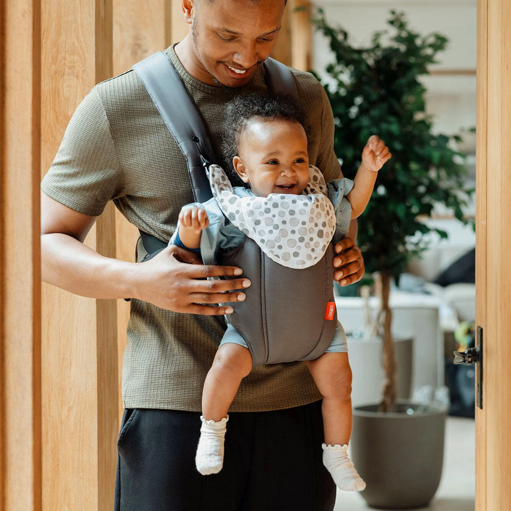 The 2 in 1 Baby Carrier by Nuby. A baby is sat inside the carrier while their Father is holding the baby with this device. Both of them are smiling.