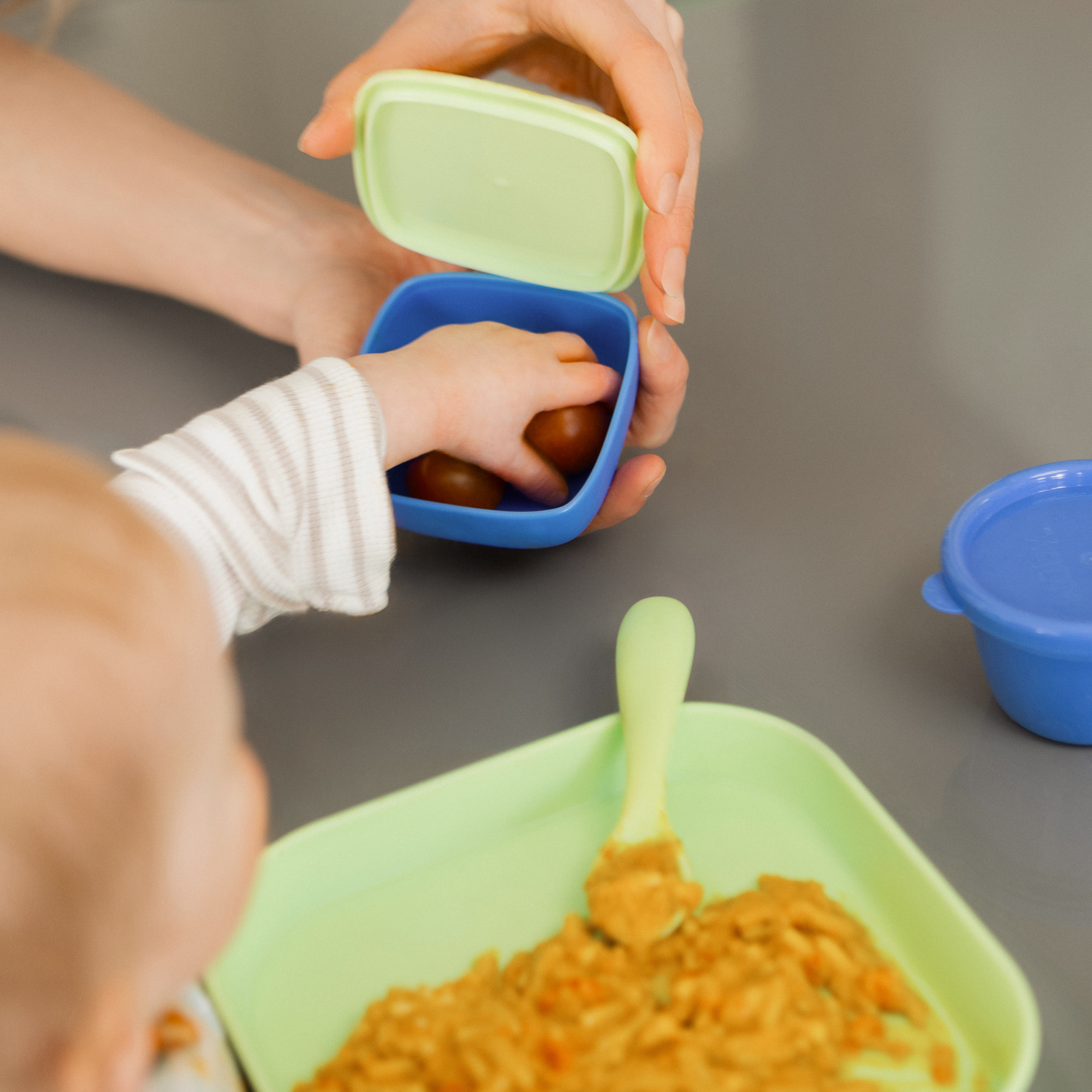Child eats from nesting food containers