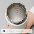 A hand holds a white Nuby RapidCool™ Baby Bottle Maker (Twin Pack) with internal markings from 60 to 240 ml. Text: Internal graduations to measure baby’s feed—perfect for travel bottle feeding.