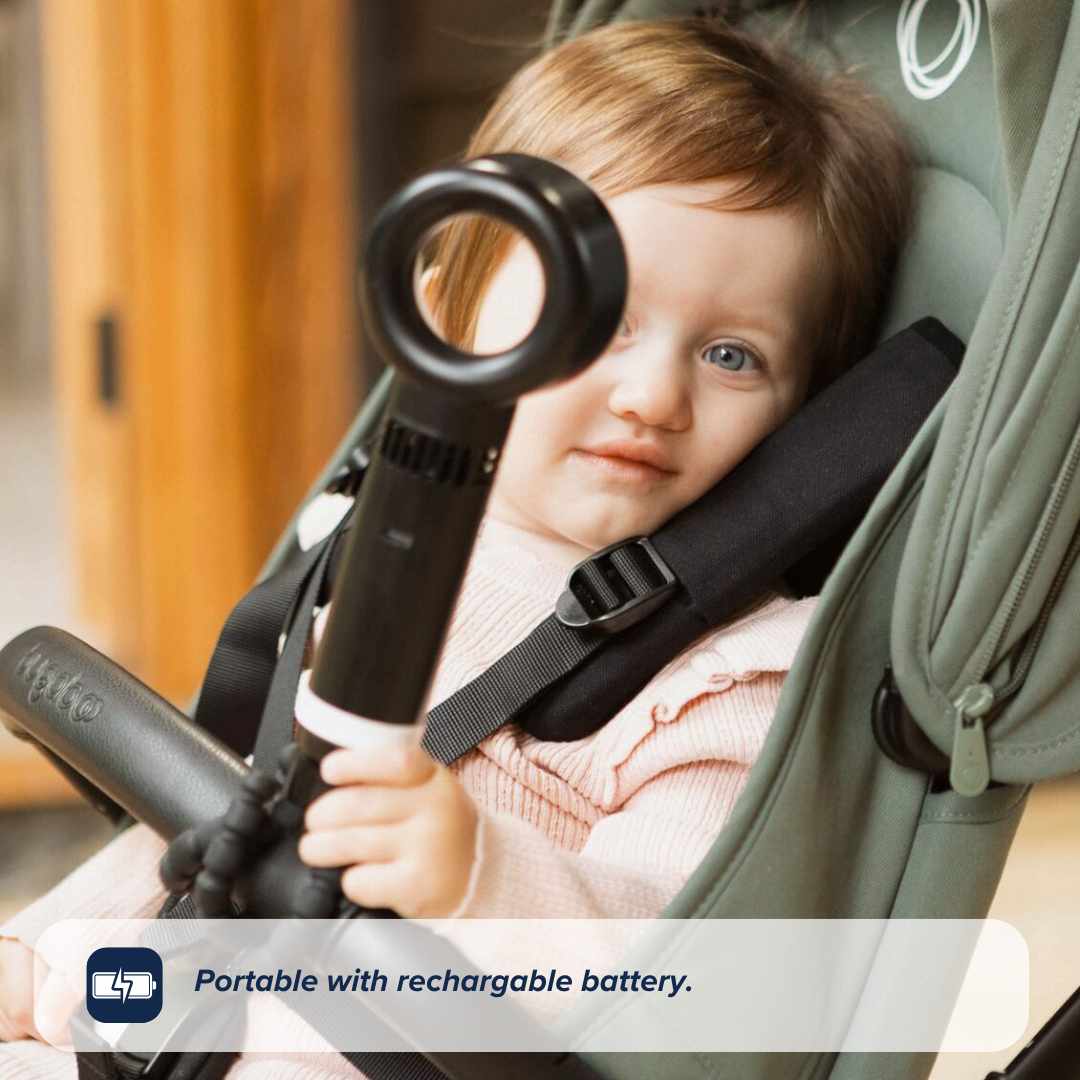 A young child in a light pink outfit sits in a green stroller, holding the Nuby UK Bladeless Pram Fan. Caption: Portable with rechargeable battery.
