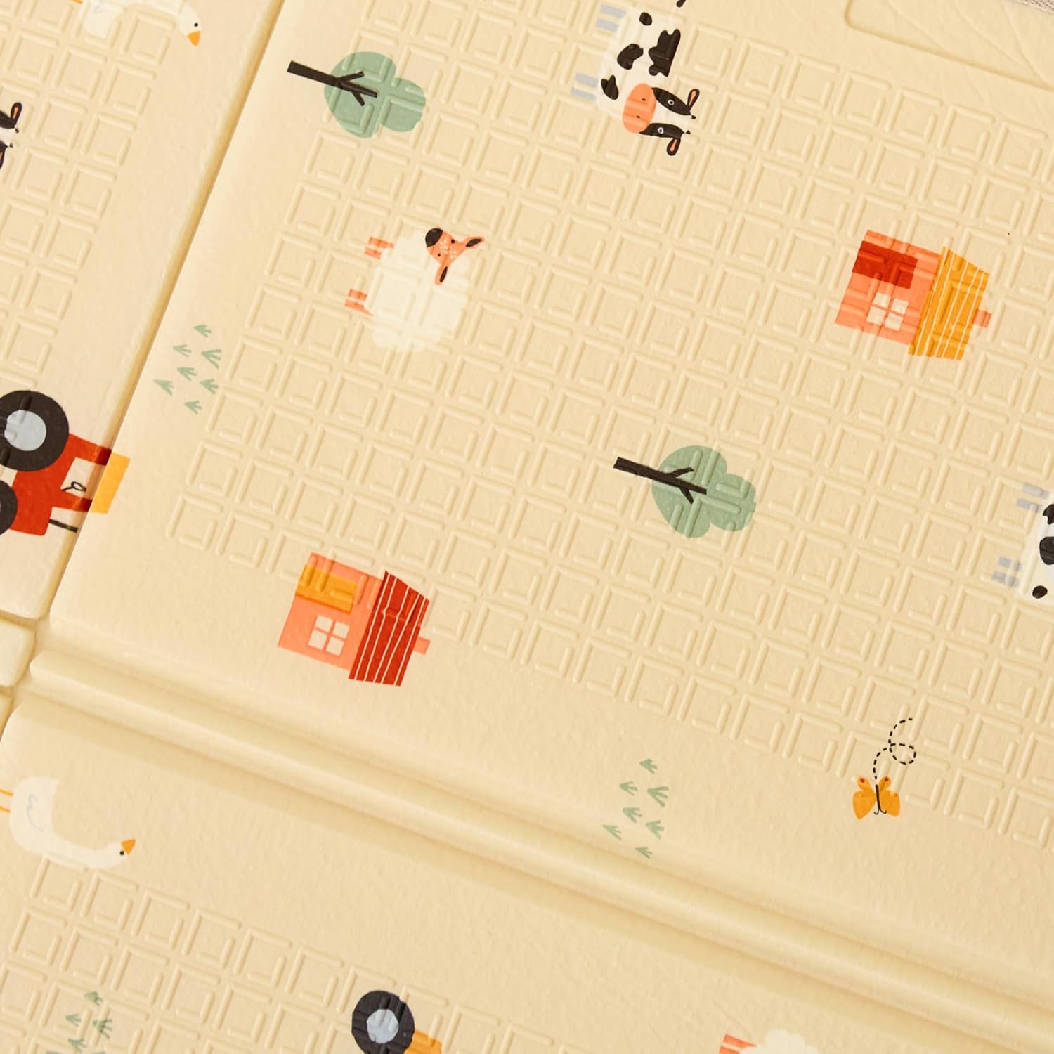 The Fold N Go Play Mat is a textured beige baby play mat featuring small illustrations of cows, chickens, trees, red farmhouses, a red tractor, and green bushes.