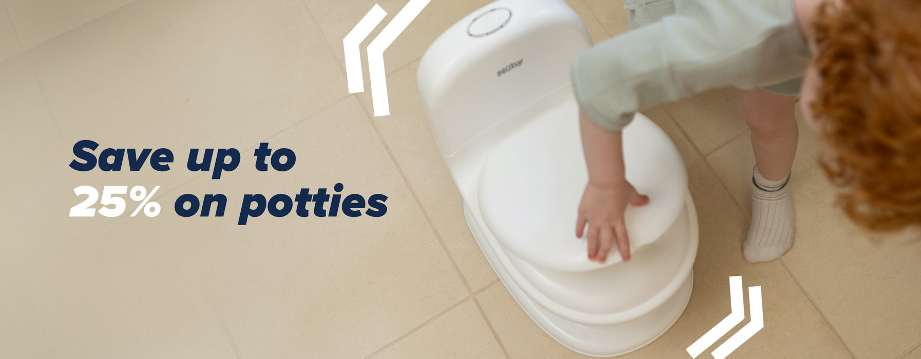 A child in a bathroom interacting with their Nuby branded potty that is in a white colour.