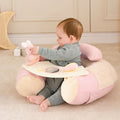 A baby enjoys cozy comfort in the Little Hops & Raindrops Sit Up Seat—in soft pink and beige—with a plush bunny toy on the built-in tray, playing happily in an inviting indoor space.