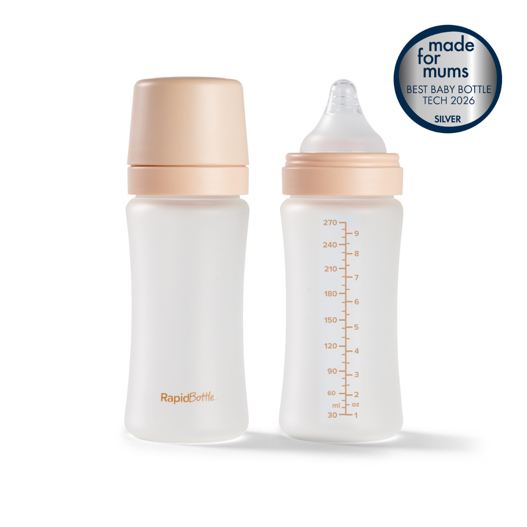 Two clear RapidBottle 2 Pack Glass Baby Bottles, 270ml (9oz), made from BPA-free glass and featuring beige caps with measurement markings. One bottle is fitted with a nipple while the other remains securely closed. A round sticker displays "made for mums BEST BABY BOTTLE TECH 2026 SILVER," highlighting their compatibility with UV sterilisers for hygienic feeding.