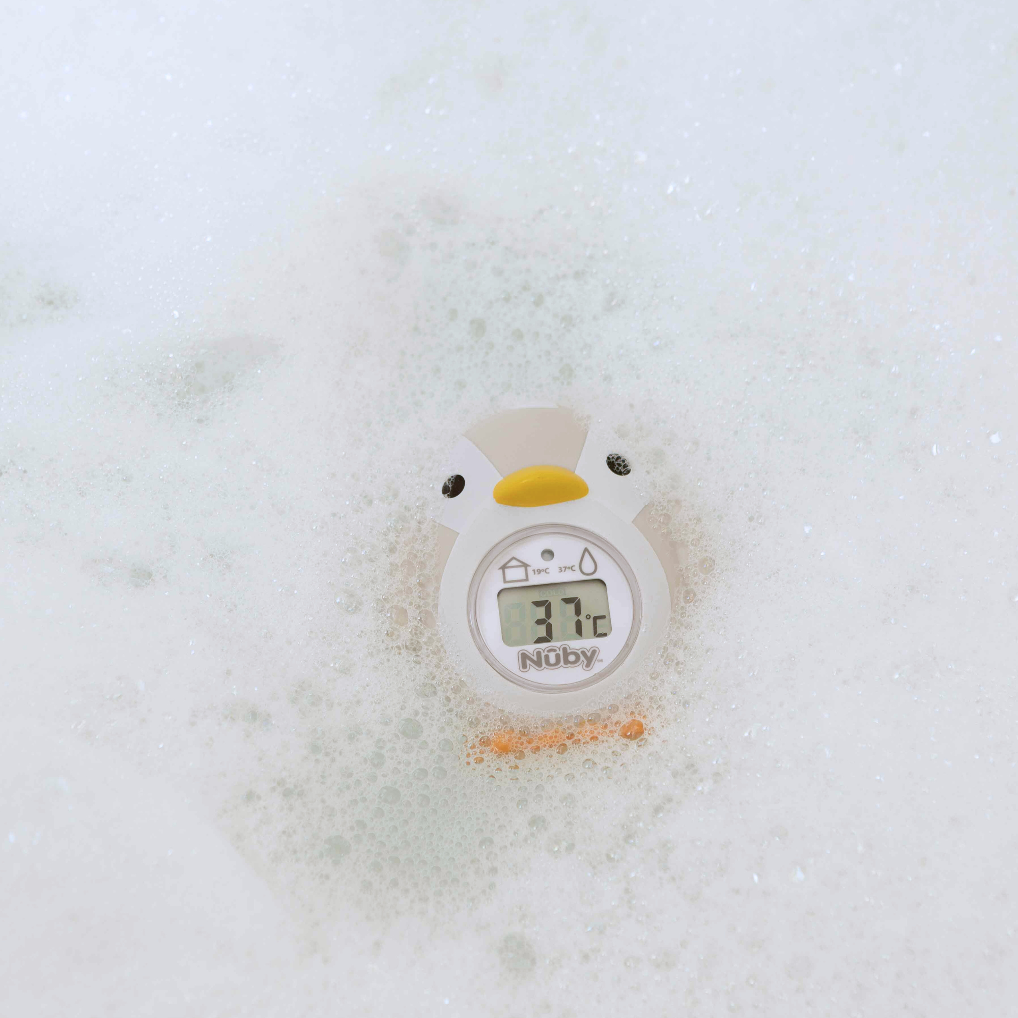 The Nuby UK Newborn Bath Support & Thermometer floats in the bath, shaped like a penguin, and displays water temperature (37.7°C) while providing cushioned support for your baby’s comfort.