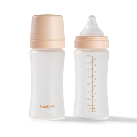 Nuby UK RapidBottle 2 Pack Glass Baby Bottles includes two BPA free bottles with beige caps—one has a nipple and measurement markings, the other a solid lid.