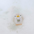 The Nuby UK Sit Me Up Bath & Thermometer Bundle includes a white and yellow penguin-shaped baby bath thermometer that floats in soapy water, displaying 37.1°C on its digital screen—ideal for safe bathing in any compact bath.