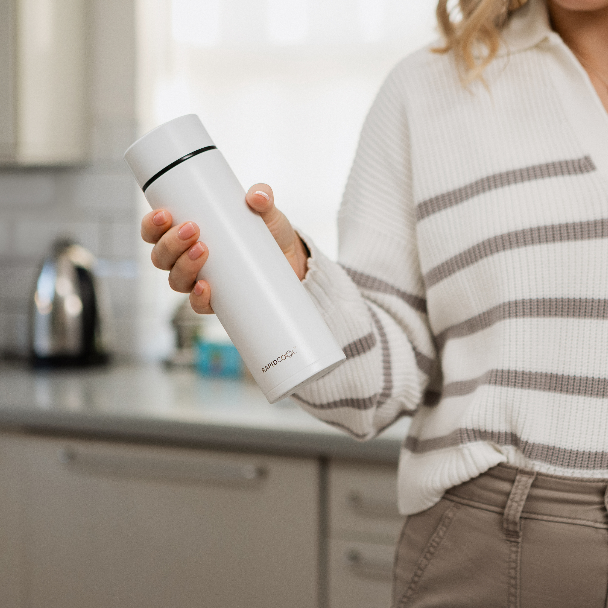 RapidCool Bottle Maker and UV Steriliser Bundle RapidCool Nuby UK. A woman holding a RapidCool in her hand as part of prep of her RapidCool Twin Pack and UV Steriliser Bundle.