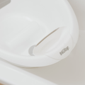 Close-up of the Nuby Sit Me Up Baby Bath in white, featuring a handle and visible Nuby logo. The compact, clean design offers smooth support for your newborns bath time.