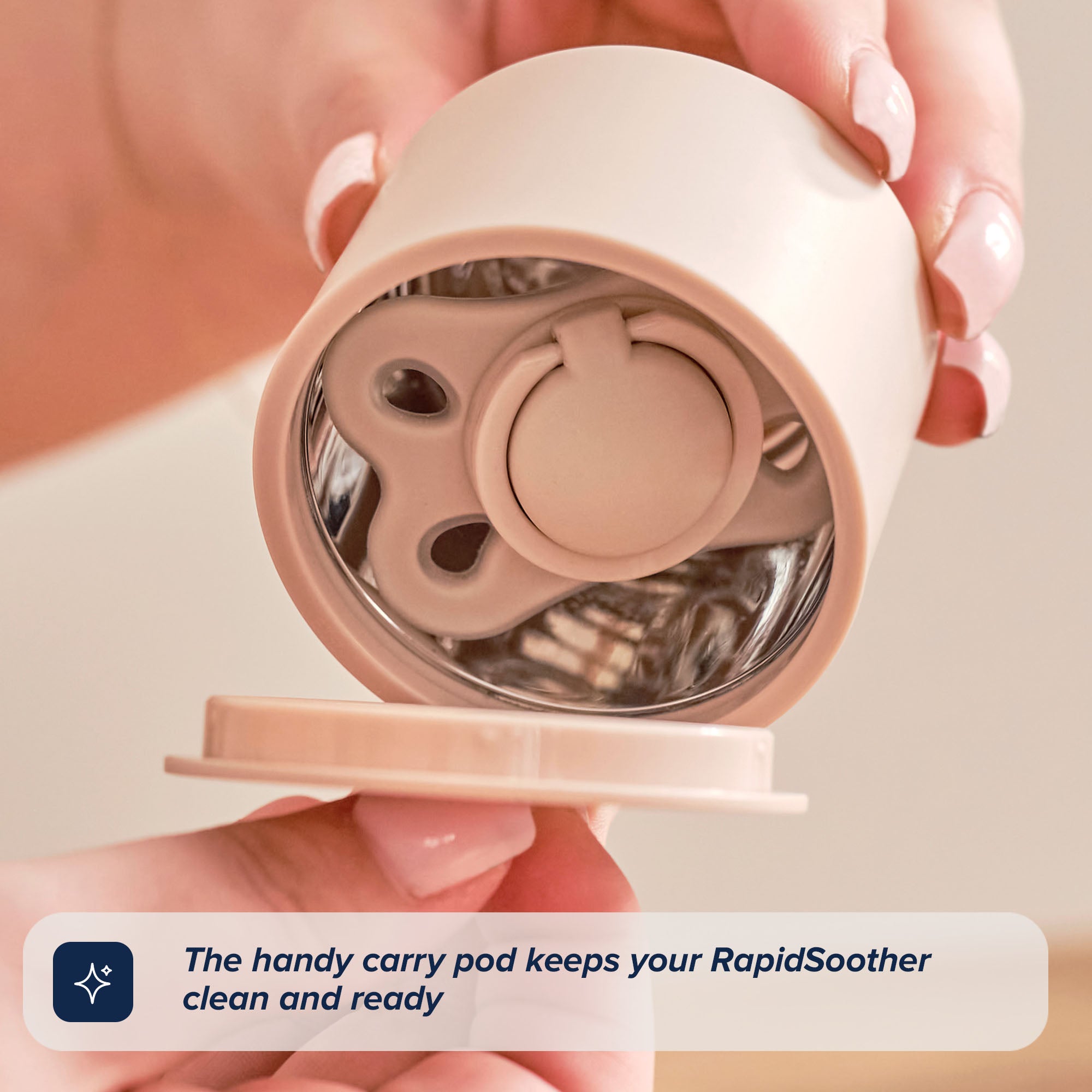 A person opens a beige container revealing one of the RapidSoother 2-pack of Dummies inside. Text in the corner reads, The handy carry pod keeps your RapidSoother clean and ready.