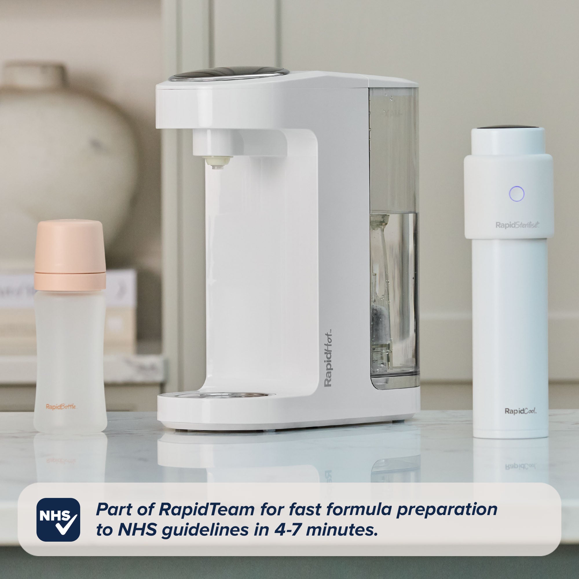 A Nuby UK countertop formula prep machine sits between RapidBottle 2 Pack Glass Baby Bottles and a RapidBottle UV steriliser. Text overlay: Part of RapidTeam—fast formula prep to NHS guidelines in 4-7 minutes.