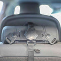 Close-up of a car headrest with a black adjustable strap and securing mechanism, designed to hold the Safe and Secure Baby Car Mirror securely in place on the seat back.