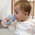 A baby drinking from the Grip N Sip Bees cup.
