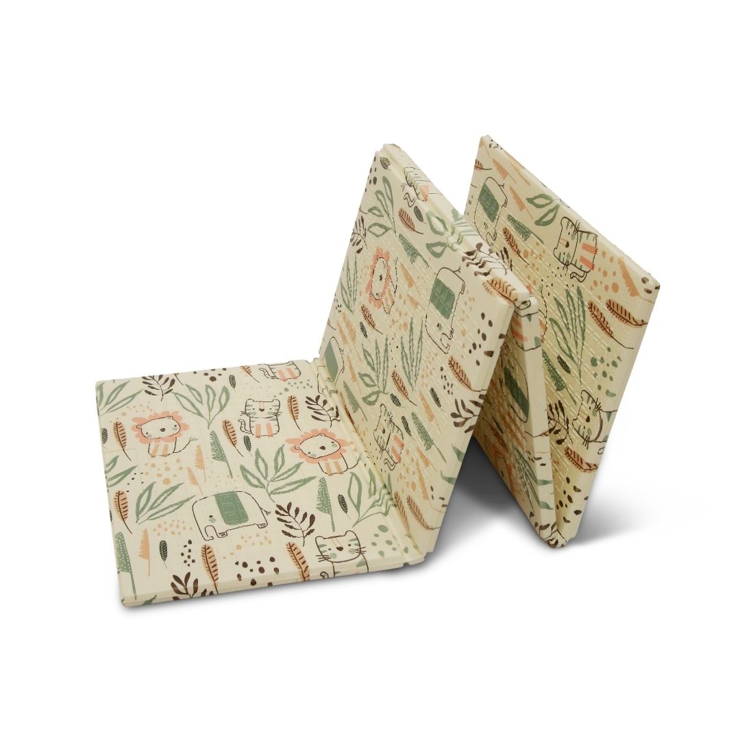 The Fold N Go Play Mat features a beige background adorned with whimsical animal illustrations and leafy patterns in green, orange, and brown tones. Shown partially folded and standing upright.