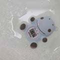 The Nuby Hippo Bath & Room Thermometer, shaped like a blue cartoon hippo, floats in soapy water and displays a digital temperature reading of 36.1°C.