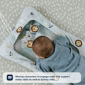 A baby enjoys tummy time on the Nuby UK Animal Adventures Playtime Set, engaging with moving animal characters under a clear surface to support motor skills.