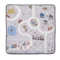 The Quilted Playmat features colorful winding roads, cars, a train, houses, trees, animals, a pond, mountains, and a hot air balloon on a gray background—perfect for tummy time and little explorers.