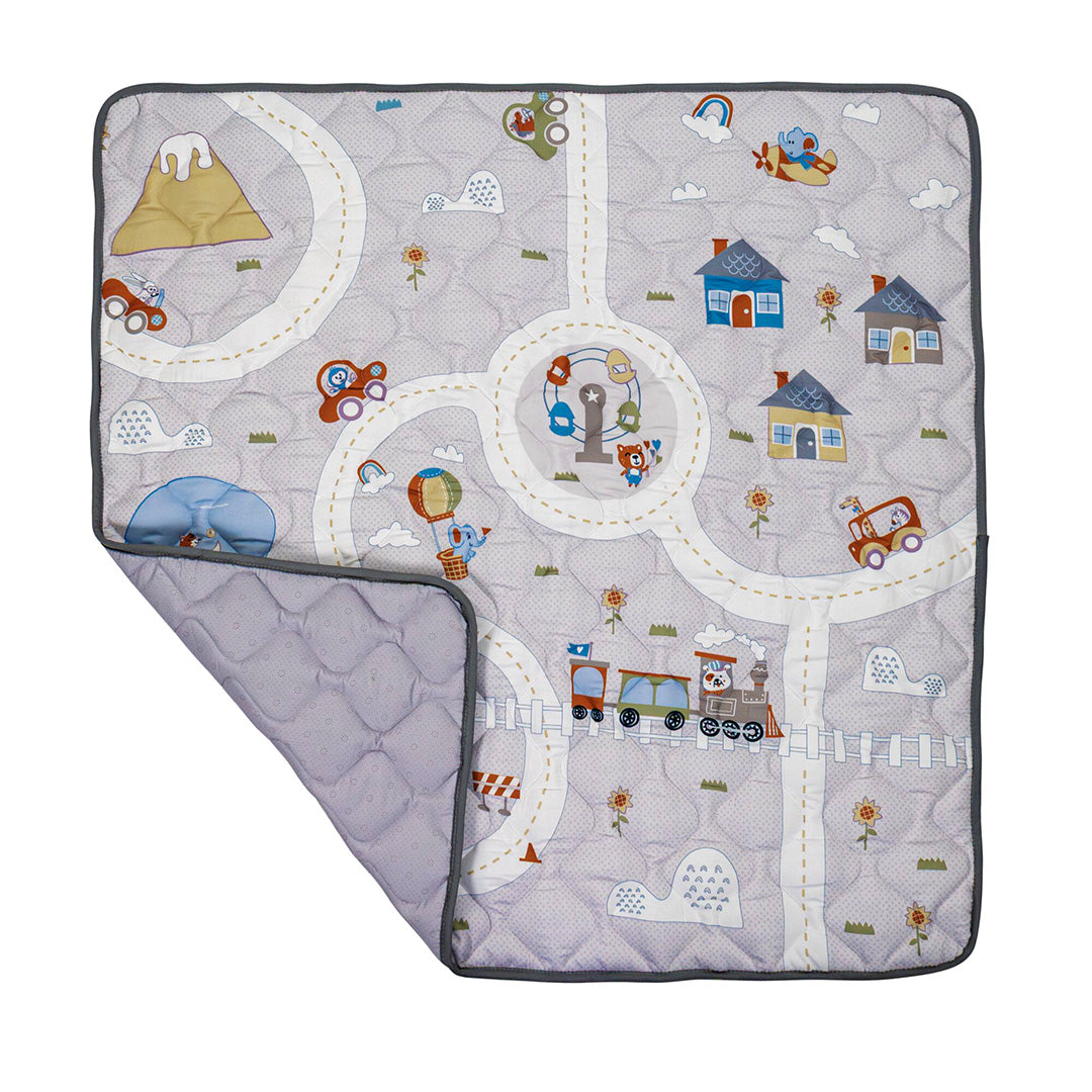 The Quilted Playmat in gray features playful illustrations of roads, cars, houses, trees, animals, and a train. This padded anti-slip baby mat has a folded corner showing its dotted reverse side for added safety and style.