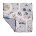 The Quilted Playmat in gray features playful illustrations of roads, cars, houses, trees, animals, and a train. This padded anti-slip baby mat has a folded corner showing its dotted reverse side for added safety and style.