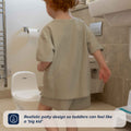A toddler stands near the My Real Mini Toilet Potty in a bathroom. Text on the image reads: Realistic potty design so toddlers can feel like a big kid.