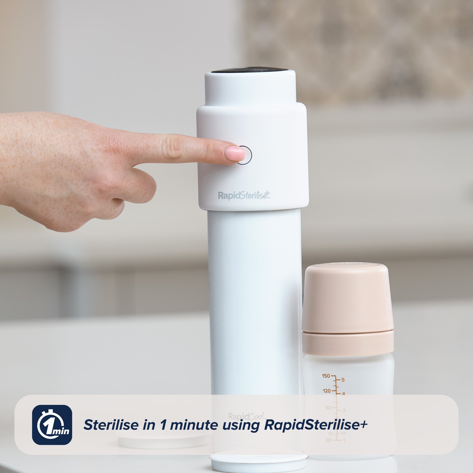 A woman's hand reaching to press the RapidSterilise+ button to begin sterilising a RapidCool sat on top of a kitchen counter. A small RapidBottle in beige is stood alongside this RapidCool.