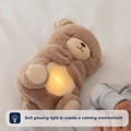 The Biscuit Bear Calming Comforter, a plush teddy with a gentle glowing belly, rests beside a sleeping child. Text overlay: “Biscuit Bear’s soft glow and soothing comfort create a peaceful bedtime environment.”.