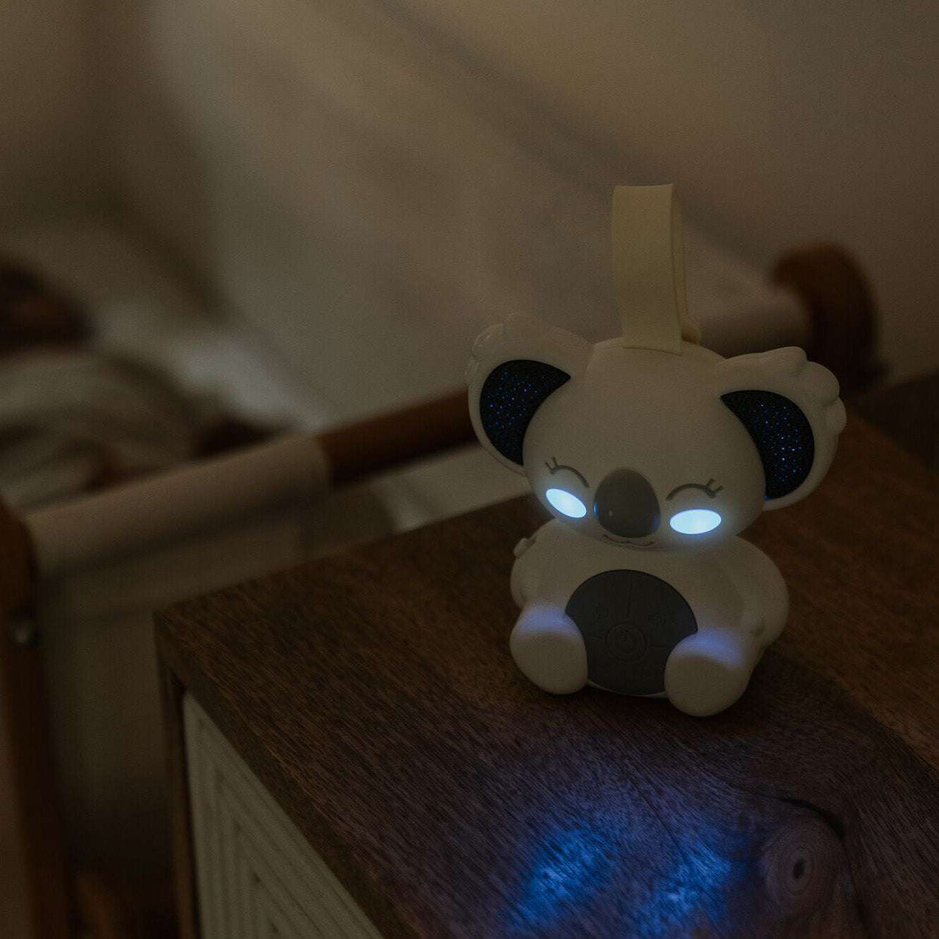 Biscuit bear night light by Nuby on a pram
