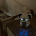 Biscuit bear night light by Nuby on a pram