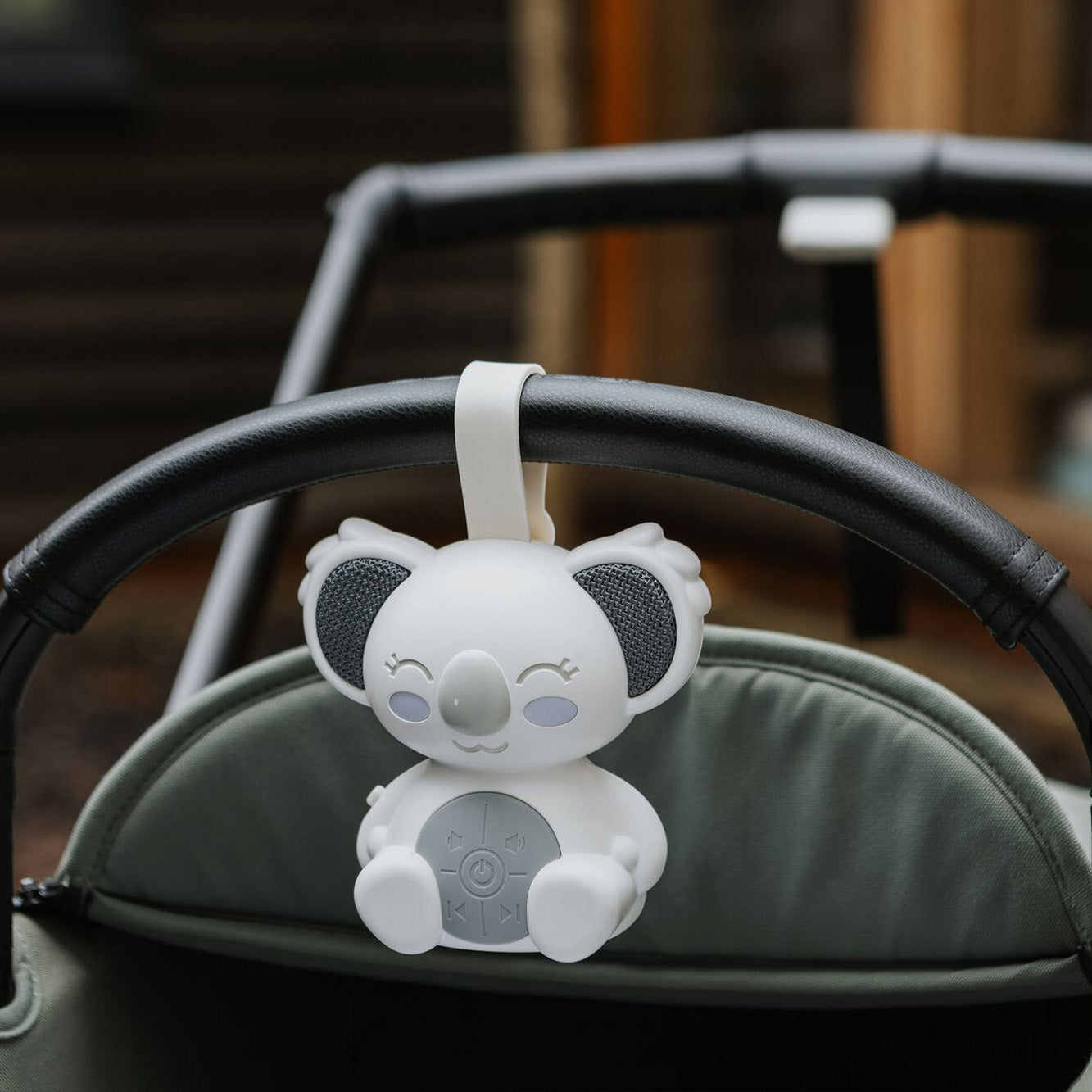 Biscuit bear night light by Nuby on a pram