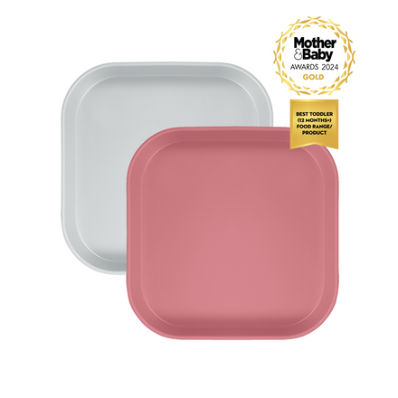 A pair of pink and white plates with a Mother & Baby Awrd 2024 ribbon on a white background. The text on the ribbon says Best Toddler (12 months+) Food Range / Product