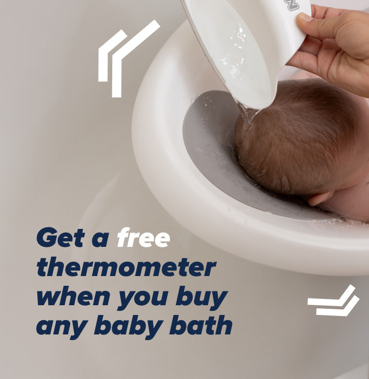 A baby with water being poured over their head by their Mother while sat in a Nuby bath.