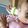 A baby eating from a Nuby Fruitsicle.