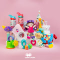 An assortment of baby essentials from the Nuby Mystery Box—including rattles, stuffed animals, water bottles, and teething rings—are arranged on a pink background with the cashforkids logo at the bottom.