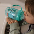 A young child drinking from the Grip n Sip cup decorated in Whales.
