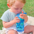 A young child drinking from their Incredible Gulp Dinosaur bottle for babies and young children by Nuby.