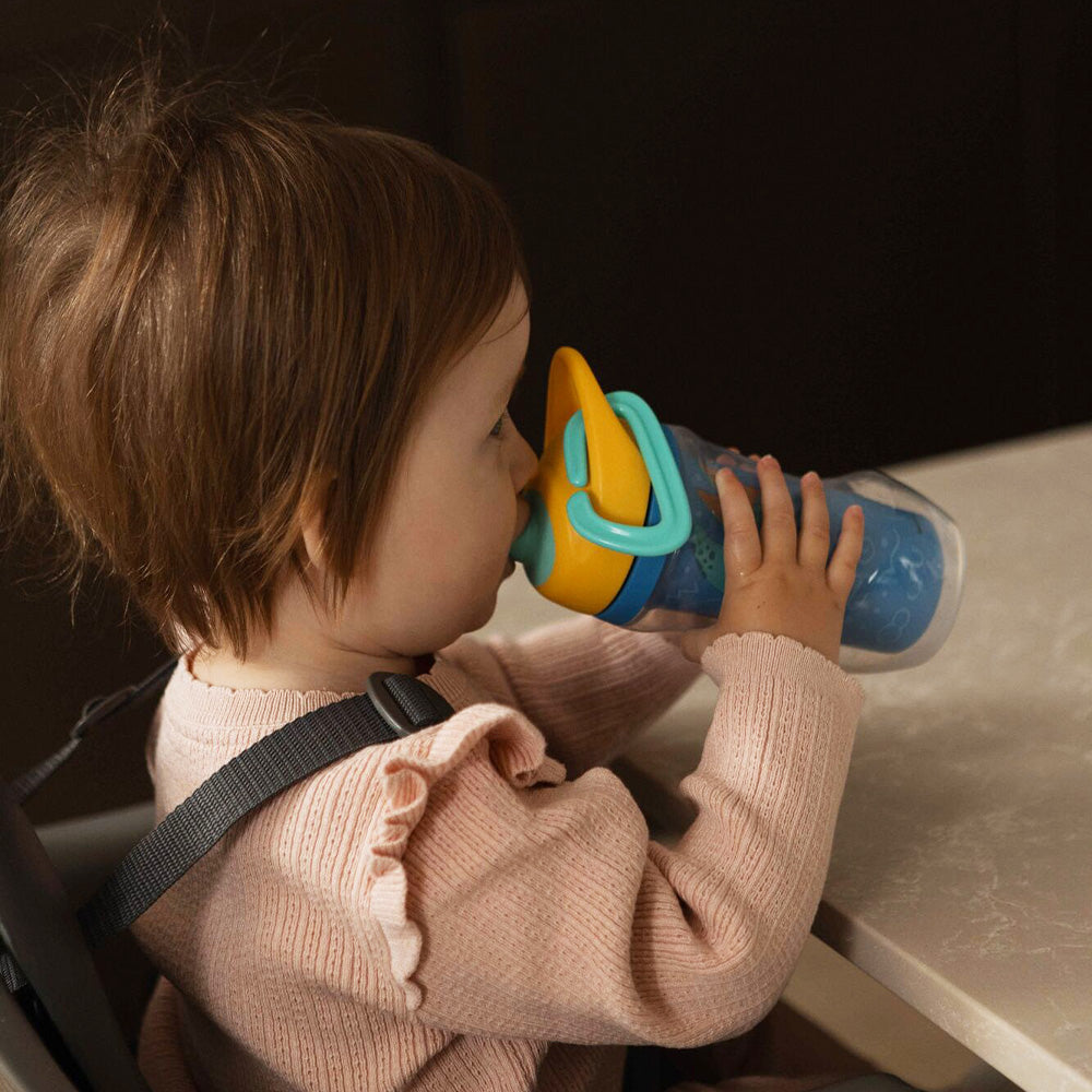 A young child holding the Insulated Sipper cup by Nuby.